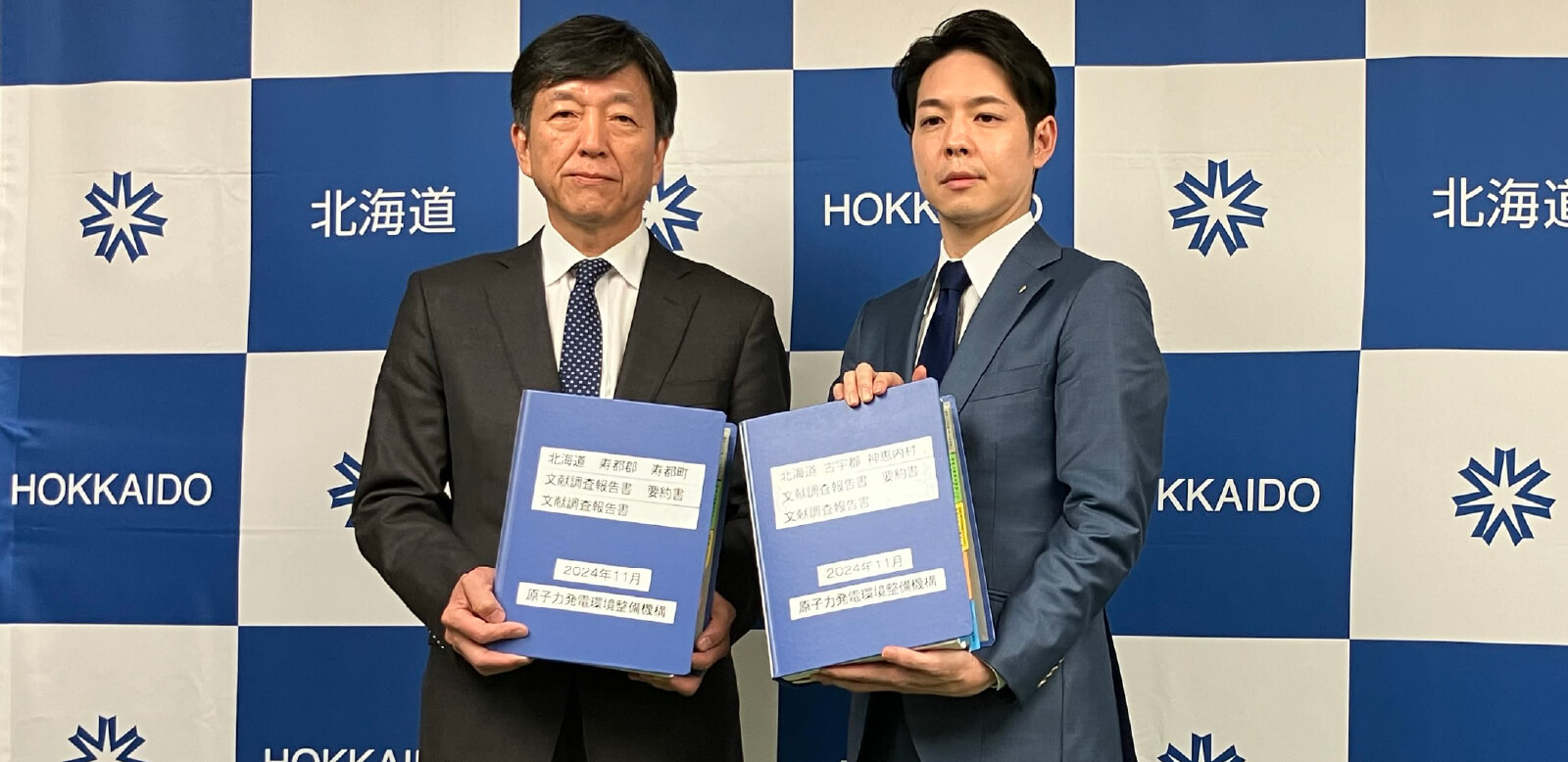 2町村の報告書を手にする鈴木知事と山口理事長（左）（北海道庁にて）